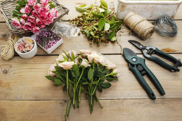 Vrouw maken boeket van roze rozen. — Stockfoto