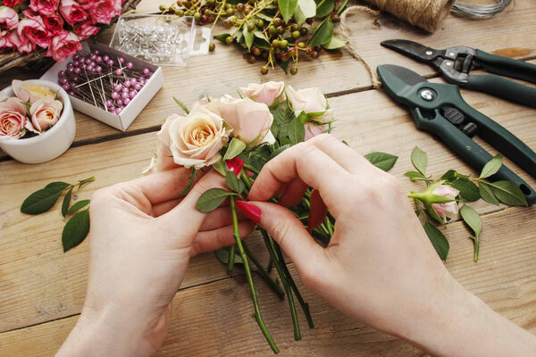 Женщина делает букет из розовых роз
.