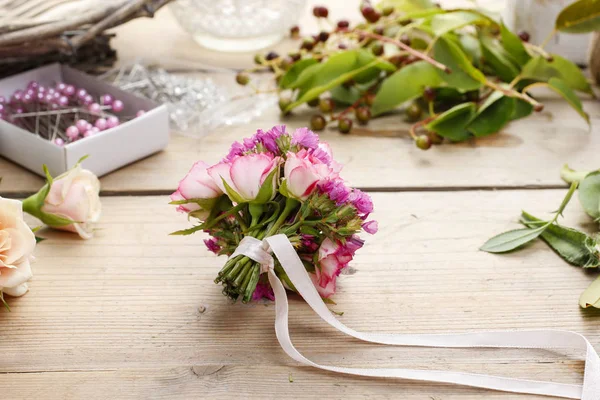 Frau macht Strauß aus rosa Rosen. — Stockfoto