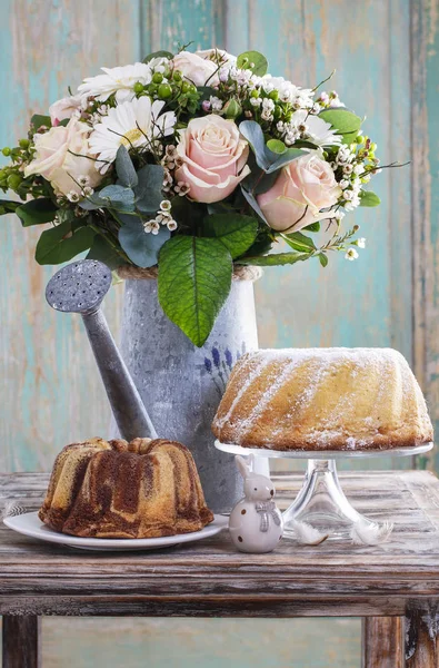 Boeket van roze rozen en witte gerbera's, Pasen taarten. — Stockfoto