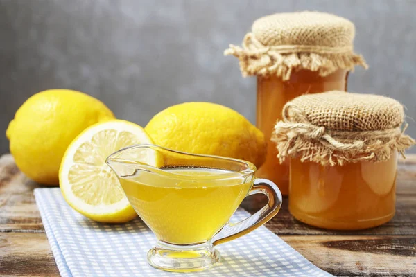 Подливка с медом и свежими лимонами на заднем плане . — стоковое фото