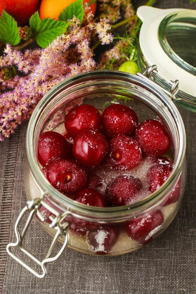 Cherries with sugar in big glass jar — Stock Photo, Image