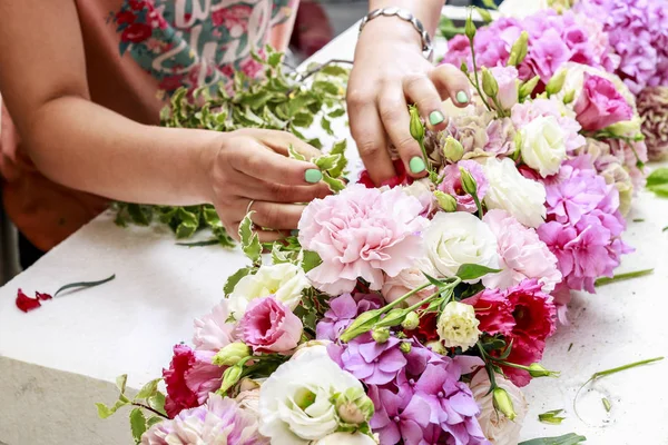 Woman making floral arrangement with carnation, eustoma and hort — Stock Photo, Image