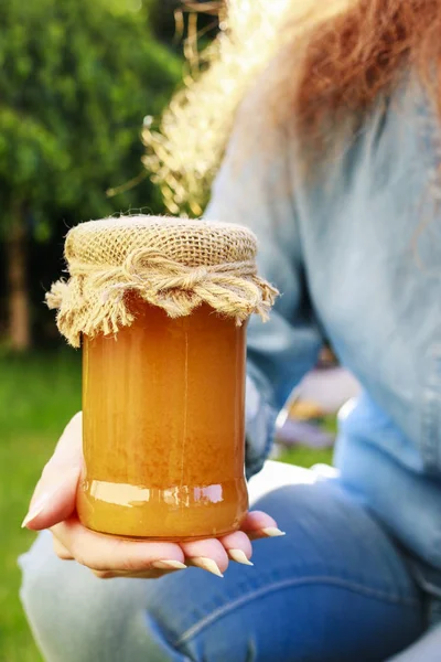 Woman holding glass jar of honey — Stock Photo, Image