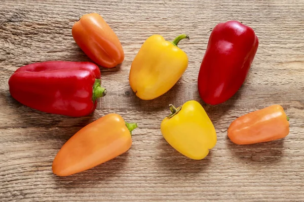Colorful peppers on wooden background — Stock Photo, Image