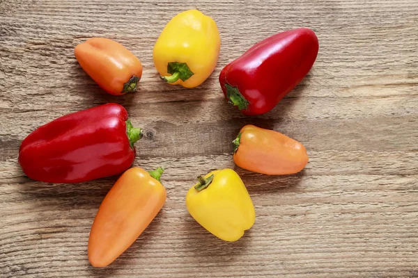 Colorful peppers on wooden background — Stock Photo, Image