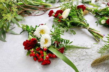 Karanfil, astra ve hypericum çiçekli küçük buketleri.