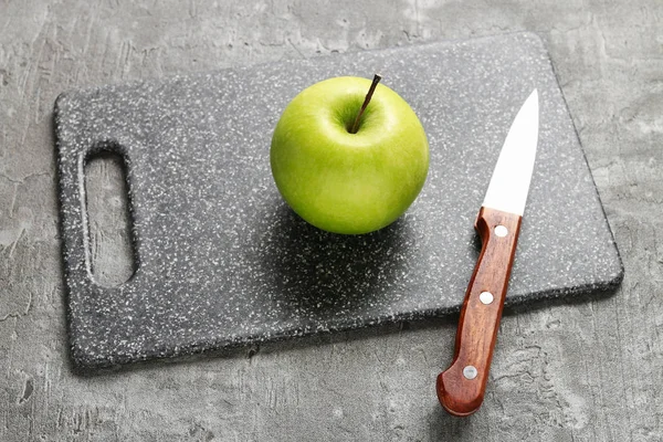 Nůž a apple na prkénku. — Stock fotografie