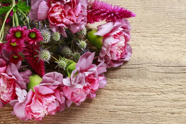 Bukett av nejlika och krysantemum blommor på brunt trä — Stockfoto