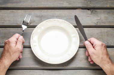 Onun yemek için boş plaka üzerinde bekleyen aç adam