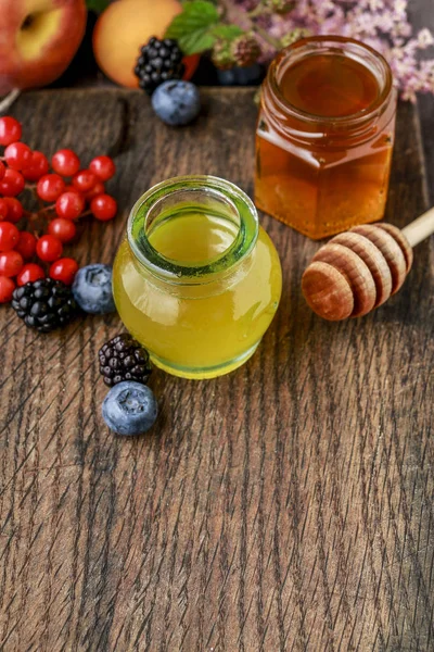 Glas mit Honig und Herbstfrüchten. — Stockfoto