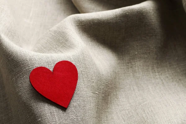 Деревянное сердце на льняной ткани — стоковое фото
