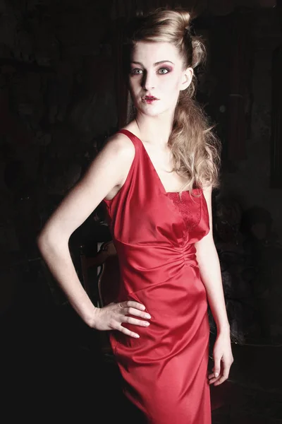 黒の背景に赤いドレスの女 — ストック写真