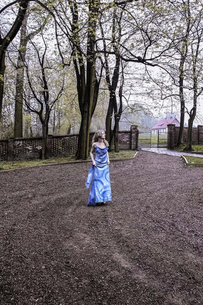 Lost and lonely woman in long blue dress wandering in old autumn — Stock Photo, Image