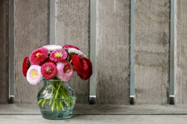 Buquê de margaridas vermelhas, rosa e brancas em vaso de vidro. Bac de madeira — Fotografia de Stock