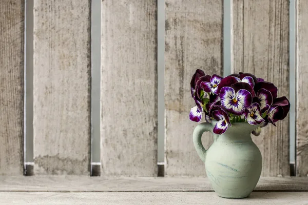 陶製の花瓶でパンジーの花のブーケ。木製の背景 — ストック写真
