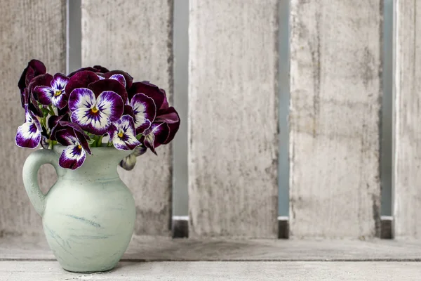 Kytice maceška květ keramická váza. Dřevěné pozadí — Stock fotografie