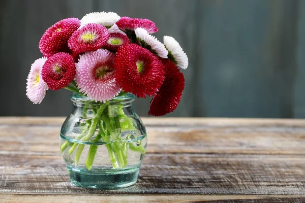 Ramillete de margaritas rojas, rosadas y blancas en jarrón de cristal . — Foto de Stock