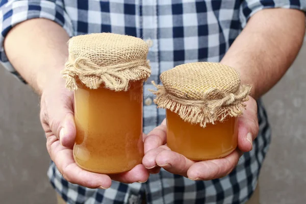 Man holding jars of honey — Stock Photo, Image