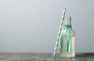 Cam şişe ve soyulmuş saman.