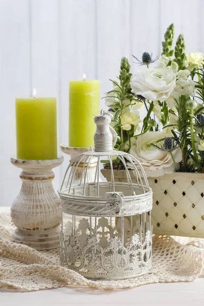 Floral arrangement with vintage bird cage and scented candles. — Stock Photo, Image