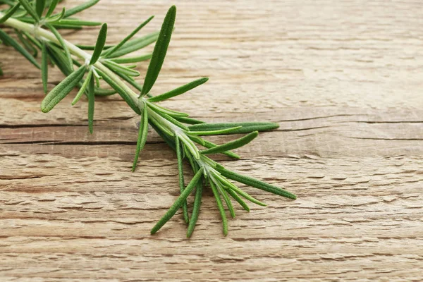 Rosmarinzweig (rosmarinus officinalis) auf Holz — Stockfoto