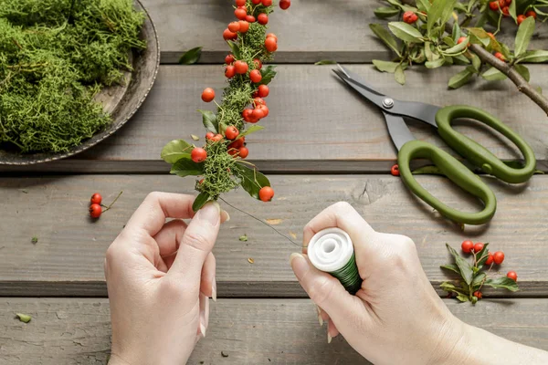 Florist i arbetet: hur man gör en krans med röda bär (cotoneas — Stockfoto