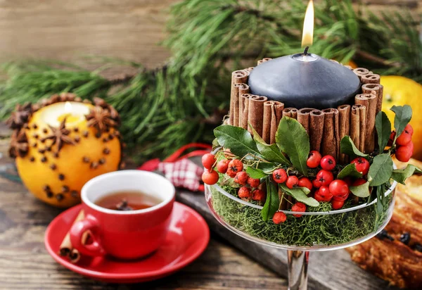 Weihnachtskerze dekoriert mit Zimtstangen und roten Beeren — Stockfoto