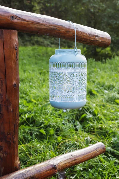 Lanterne vintage bleue suspendue à une clôture en bois dans le jardin . — Photo