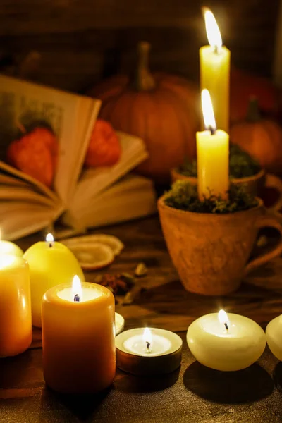 Autumn decorations: candles on wooden table in the evening. — Stock Photo, Image