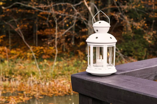 White lantern at the wooden pier in autumn wetland forest. — Stock Photo, Image