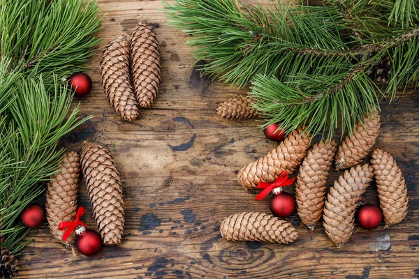 Cones and fir branches on wooden background. — Stock Photo, Image