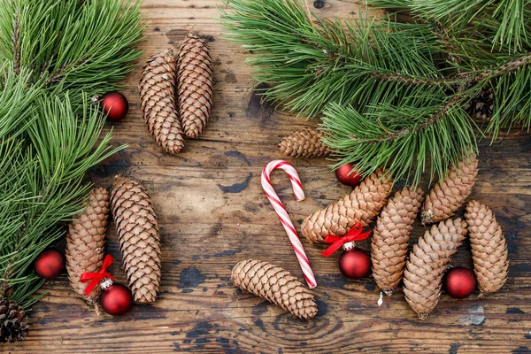 Cones and fir branches on wooden background. — Stock Photo, Image