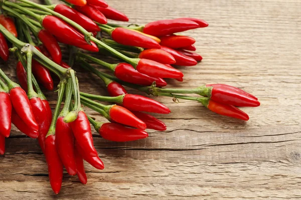Rode hete chili pepers op oude houten tafel — Stockfoto