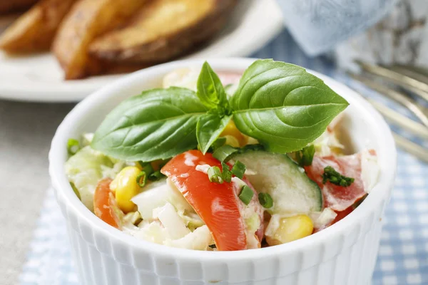 Овощной салат, украшенный листом базилика — стоковое фото