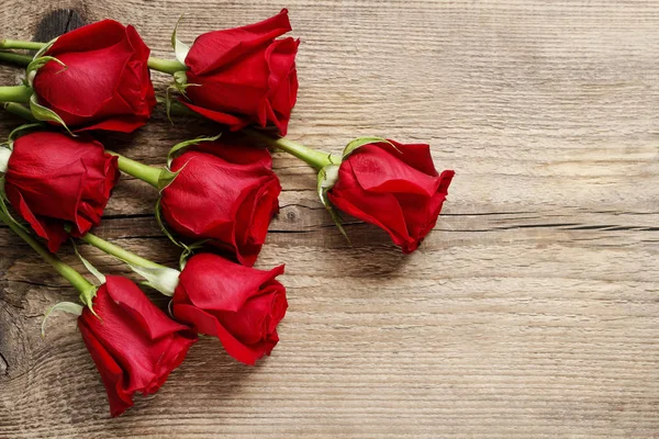 Красные розы на деревянном фоне — стоковое фото