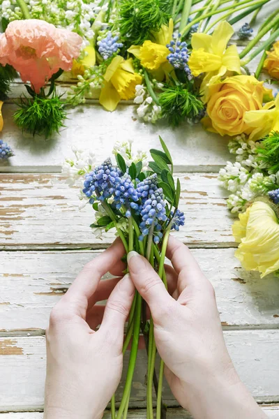 Woman arranging bouquet of springtime flowers. — Stock Photo, Image