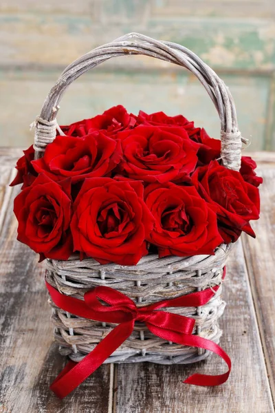 束在柳条篮子里的红玫瑰 — 图库照片