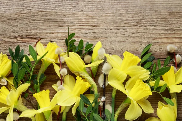 Mooie gele narcissen op bruin houten tafel. — Stockfoto