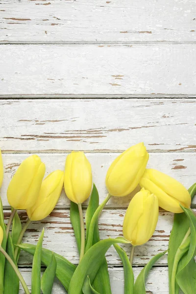 Tulipas amarelas bonitas em fundo de madeira . — Fotografia de Stock