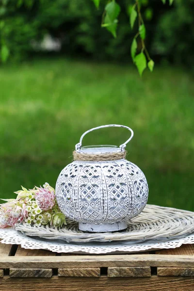 Lanterne blanche et bouquet de fleurs dans le jardin . — Photo