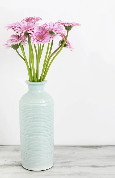 Flores de gerbera rosa em vaso de cerâmica azul, fundo branco — Fotografia de Stock