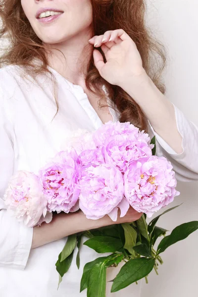 Mujer sosteniendo peonías rosadas — Foto de Stock