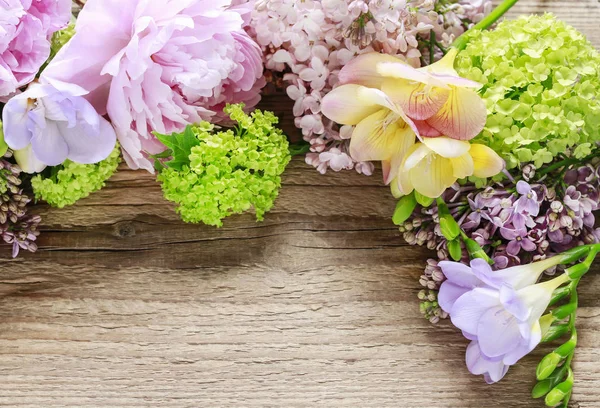 Lilacs, peônias e guelder verde rosa (viburnum opulus) sobre madeira — Fotografia de Stock