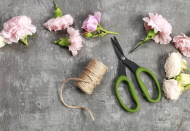 Çiçekçi işyeri: Karanfil ve taş zemin üzerine gül.