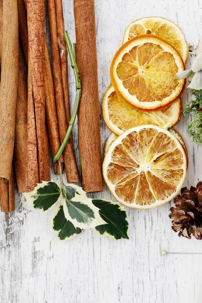 Palitos de canela, laranjas secas e galho azevinho — Fotografia de Stock