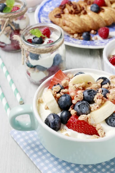 Bowl of yogurt with muesli and fresh fruits: strawberries, blueb