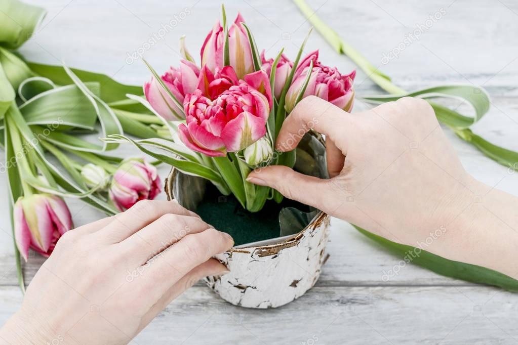 Florist workplace: how to make decoration with pink tulips insid