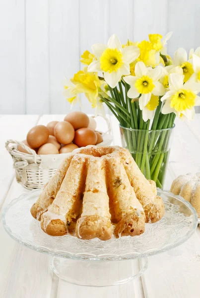 Traditional easter cake and bouquet of daffodils