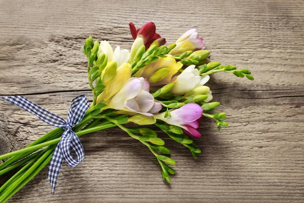 Kleurrijke fresia's bloemen op houten achtergrond — Stockfoto